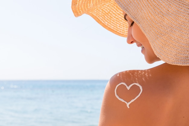 Heart made of sunscreen on a woman's shoulder