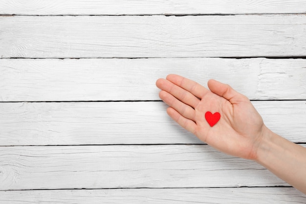 Foto cuore in mano dell'uomo su una superficie di legno. v