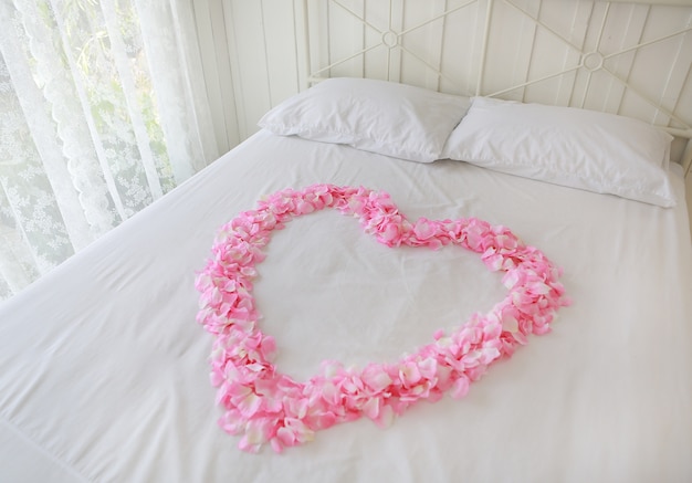 Photo heart of red petals on a bed