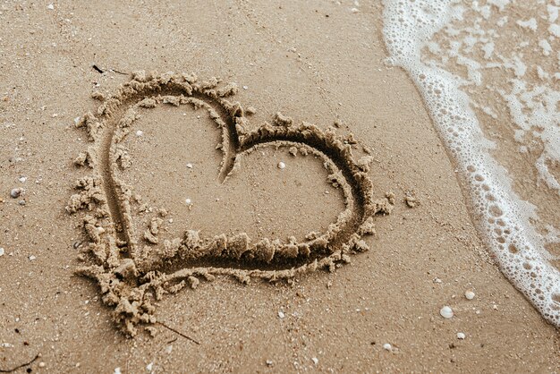 Photo heart on the sand beach. conceptual love