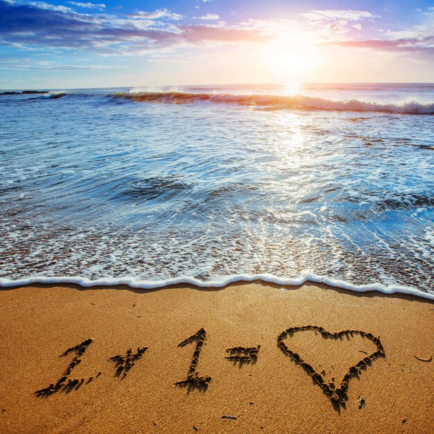 Foto cuore sulla spiaggia di sabbia. composizione romantica.