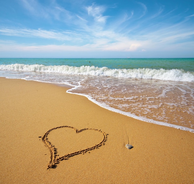 Heart on the sand of a beach. Romantic composition.