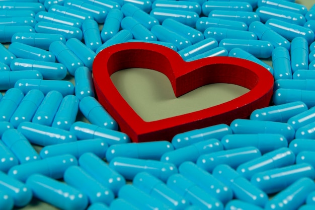 心臓の形状と青いカプセル 薬物治療の重要性