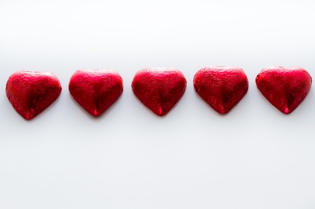 Heart shape chocolate candies on white background.