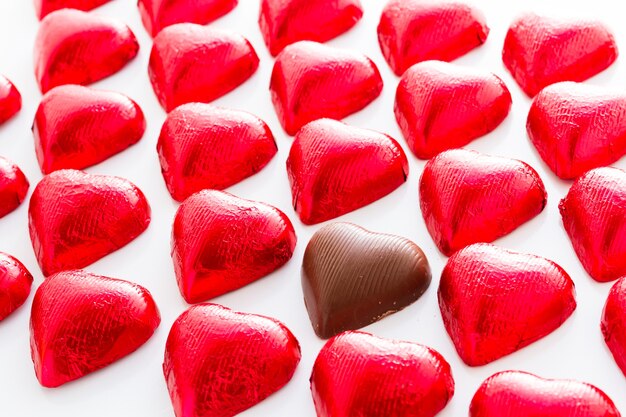 Heart shape chocolate candies wrapped in red foil for Valentine's Day.