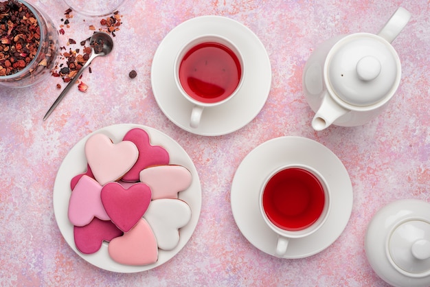 Biscotti a forma di cuore con glassa al tè di bacche. concetto: tea party di san valentino, tavola festiva in rosa.