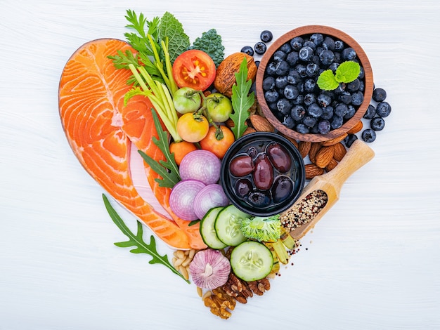 Photo heart shape of ketogenic low carbs diet concept. ingredients for healthy foods selection on white wooden background.