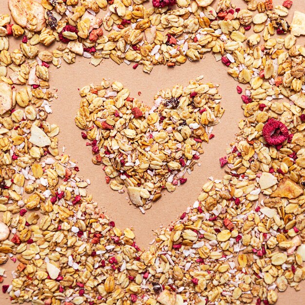 Heart shape made of granola on a beige background