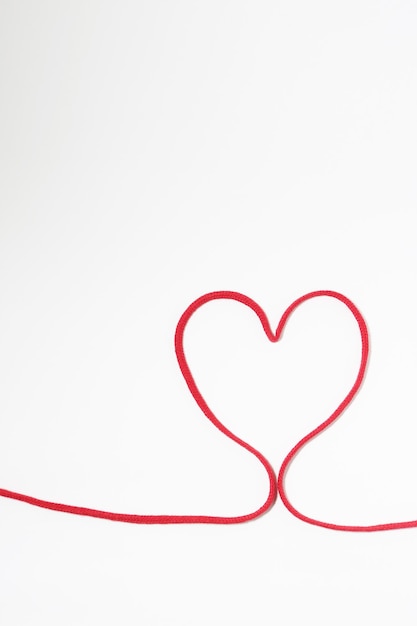 Photo heart shape made with red string on white background