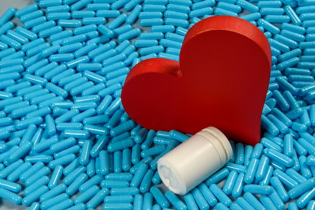 heart shape and medicine capsules representing heart problems and treatment