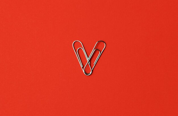 Heart shape paper clips on a red background