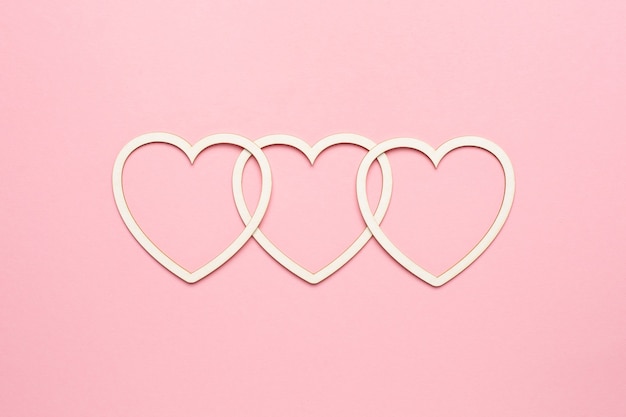 Forma di cuore su sfondo rosa pastello. carta di san valentino di concetto. vista dall'alto, copia spazio per il testo