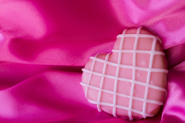 Heart shape pink cookie with icing.