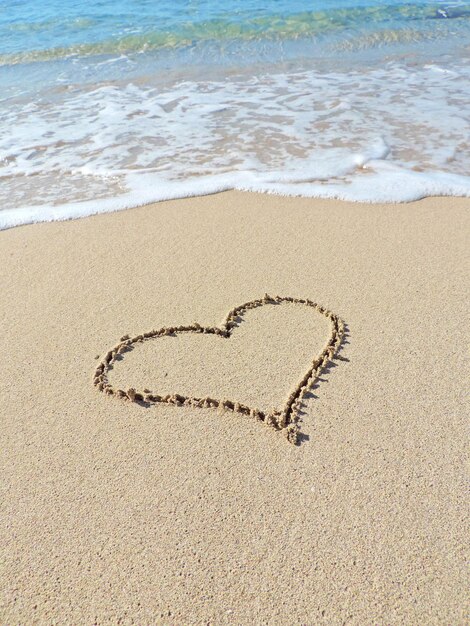 Foto forma di cuore sulla sabbia della spiaggia