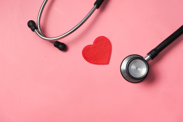 heart shape symbol and stethoscope on pink