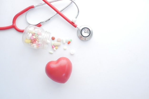 Heart shape symbol and stethoscope on white surface