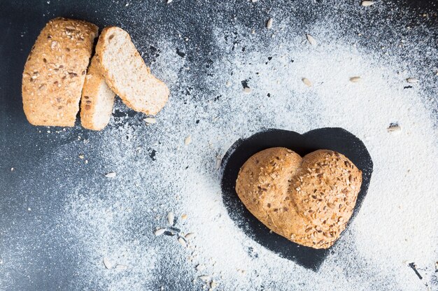 Heart shape of wholemeal bread on blackboard backround