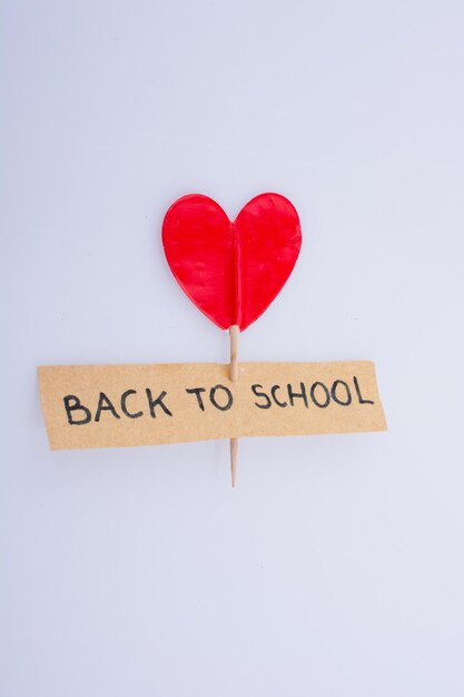 Foto a forma di cuore con un titolo di ritorno a scuola su sfondo bianco