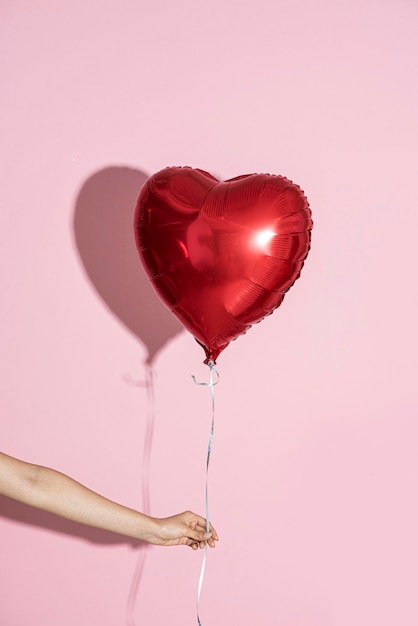 Foto palloncino a forma di cuore su sfondo rosa