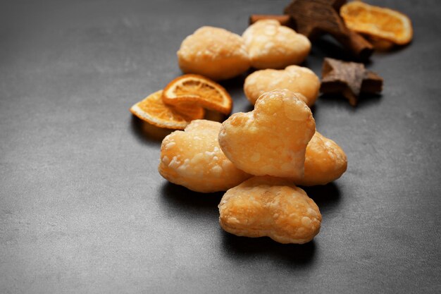 Heart shaped biscuits with dried spices on dark grey background