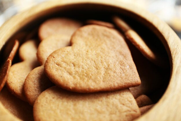 Heart shaped biscuits in wooden bowl, closeup