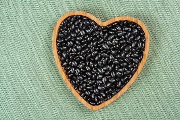 Heart shaped black bean bowl on green tablecloth