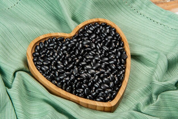 Heart shaped black bean bowl on green tablecloth