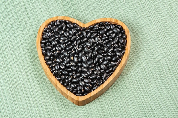 Heart shaped black bean bowl on green tablecloth