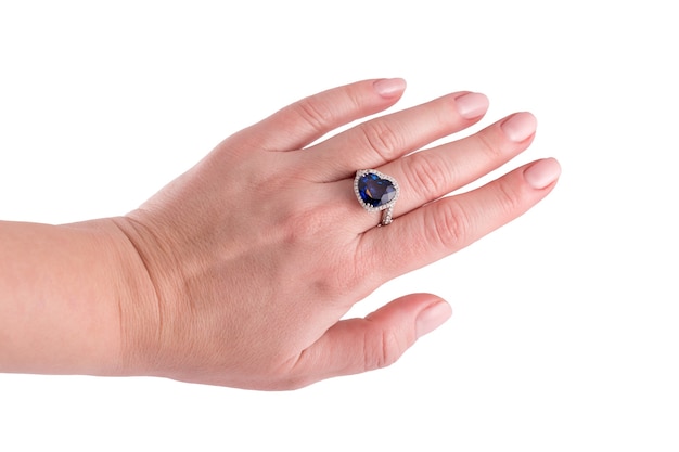 Heart shaped blue sapphire precious ring on woman hand isolated on white background