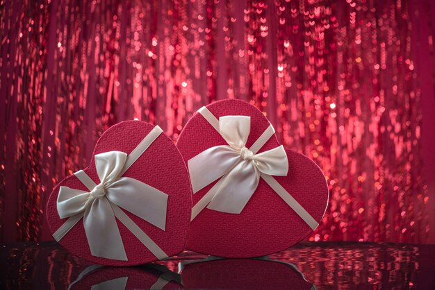 Heart shaped box lovers gifts on the mirror surface red shining bokeh background