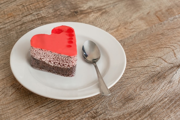 Foto torta a forma di cuore, dessert dolce, cibo di san valentino sulla piastra con spazio di copia.