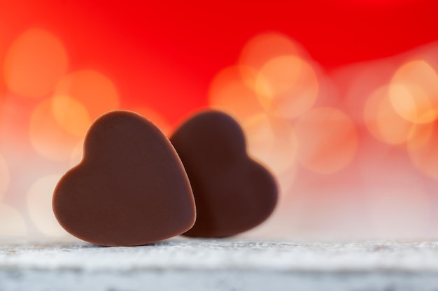 写真 ボケ幸せなバレンタインデーのグリーティング カードと赤の背景にハート形のチョコレート