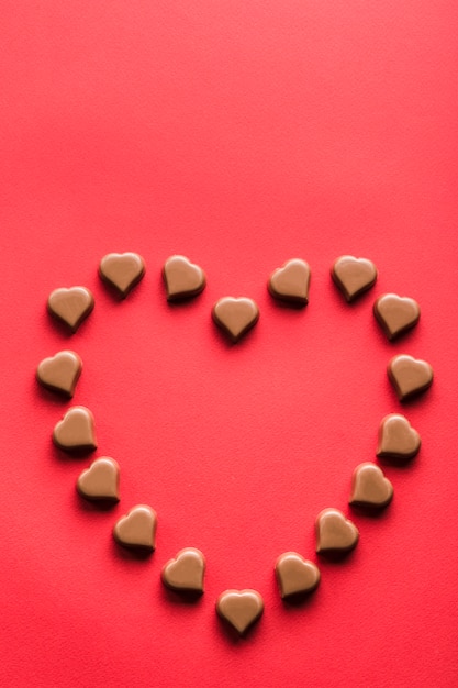 Heart shaped chocolates on red background for Valentine's day