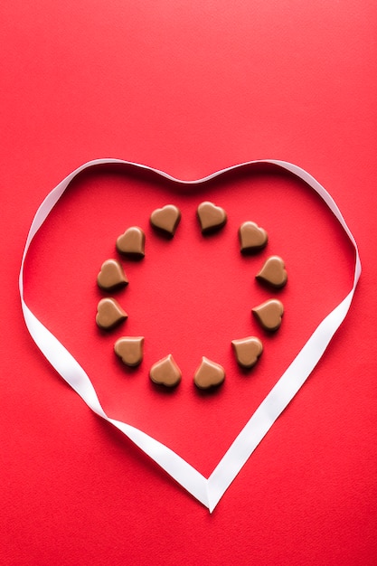 Heart shaped chocolates on red background for Valentine's day