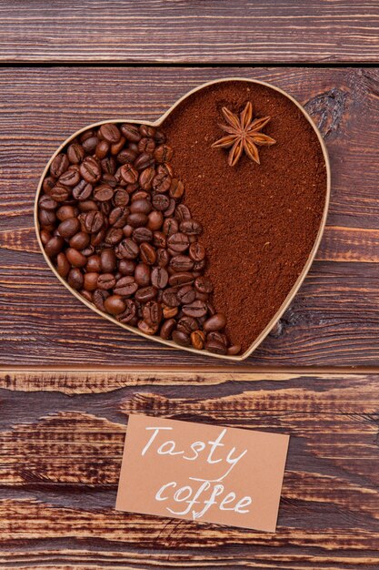 Heart-shaped coffee coffee beans and instant coffee. Tasty coffee concept. Brown wooden surface .