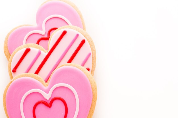 Heart shaped cookies decorated fancy icing patterns.