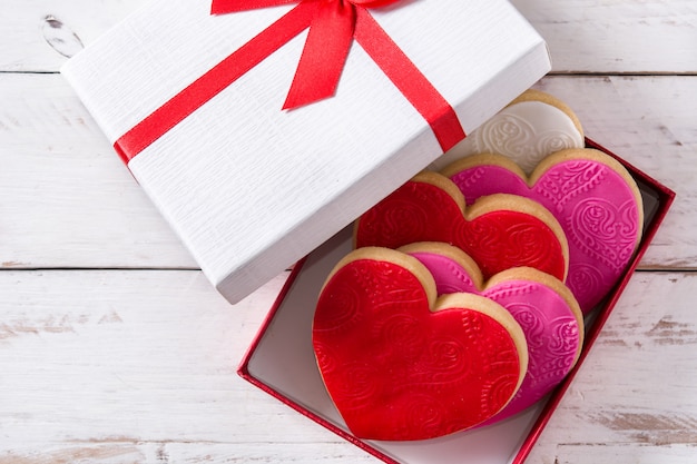 Heart-shaped cookies and roses for Valentine's Day on white wooden table, Top view