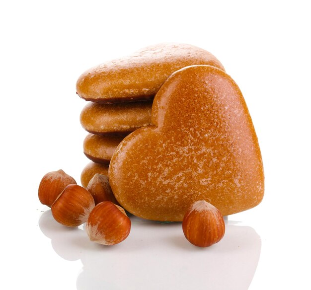 Heart-shaped cookies in stack with hazelnuts isolated on white