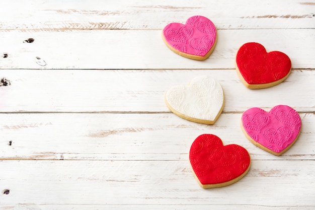 Печенье в форме сердца на день Святого Валентина на белом деревянном столе, копией пространства