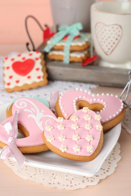 Heart shaped cookies for valentines day on plate, on color wooden background