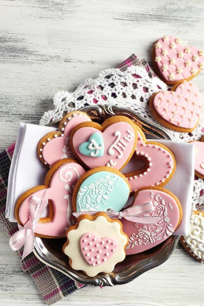 Heart shaped cookies for valentines day on plate, on color wooden background