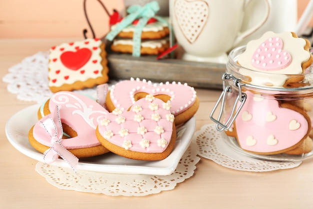 Heart shaped cookies for valentines day on plate, on color wooden background