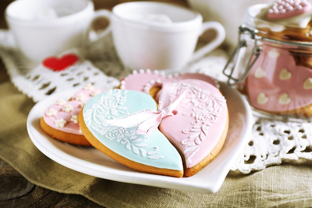 Heart shaped cookies for valentines day and teapot on  wooden background