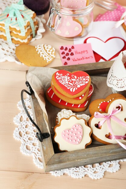 Heart shaped cookies for valentines day on tray, on color wooden background