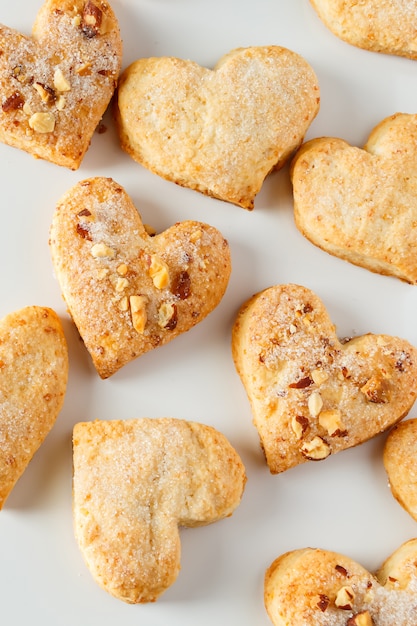 Biscotti a forma di cuore su bianco per il giorno di biglietti di s. valentino.