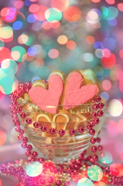 추상 흐릿한 bokeh 배경에 분홍색 설탕을 입힌 하트 모양의 쿠키 발렌타인 하트 쿠키 발렌타인 데이 장식 화려한 장식 쿠키