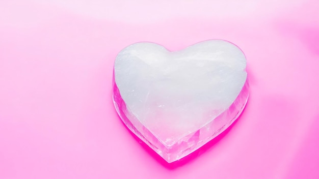 心の形の氷の立方体をピンクの背景にバレンタインデーのコンセプト愛とロマンス