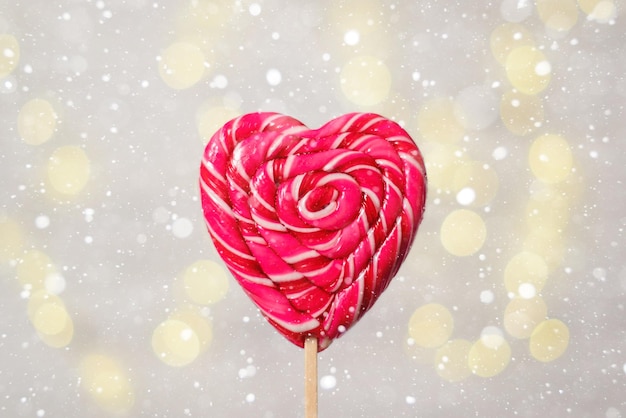 Heart shaped lollipop on a white background with bokeh