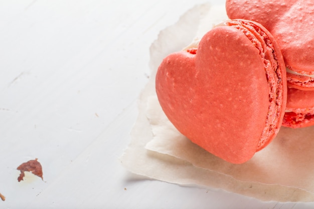 Heart shaped macaroon on white wood background