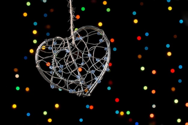 Heart shaped metal cage on bokeh light background